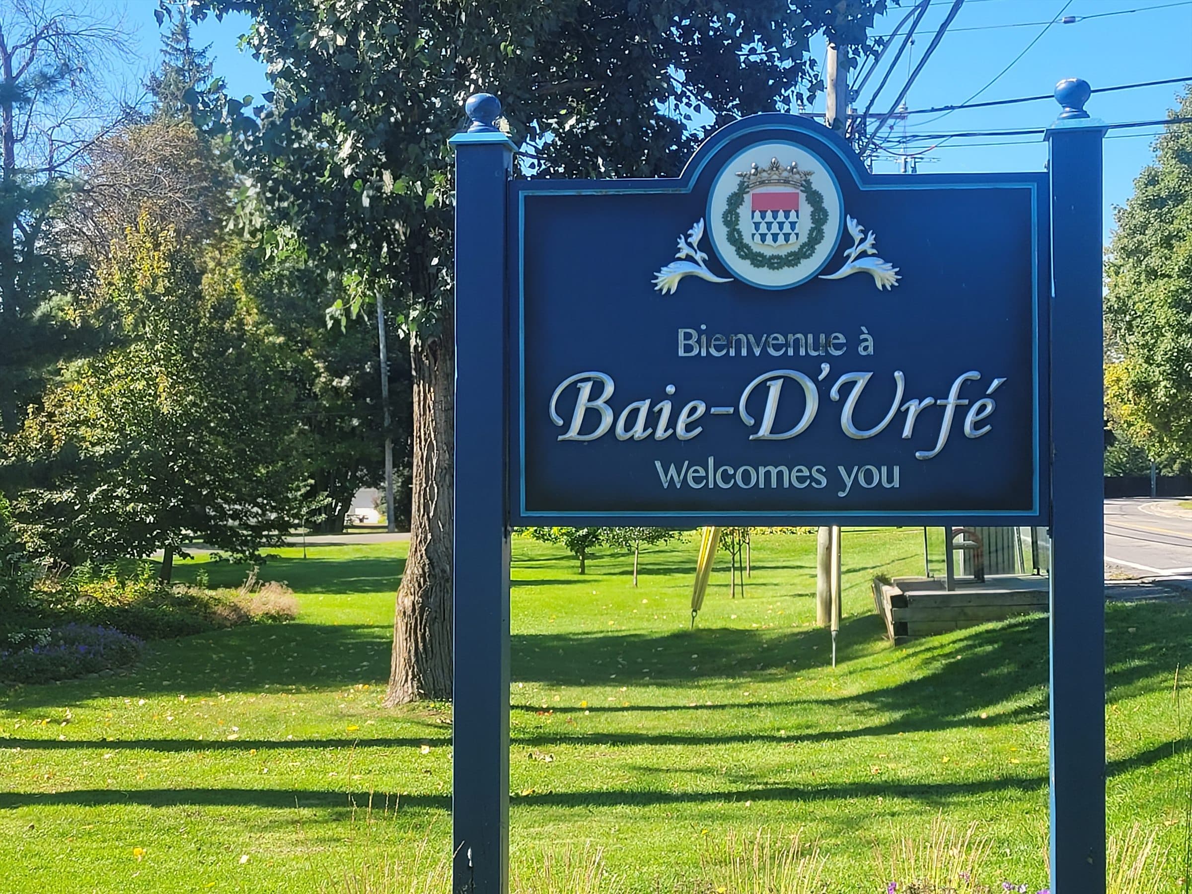 Baie-D’Urfé welcome sign surrounded by lawn and mature trees