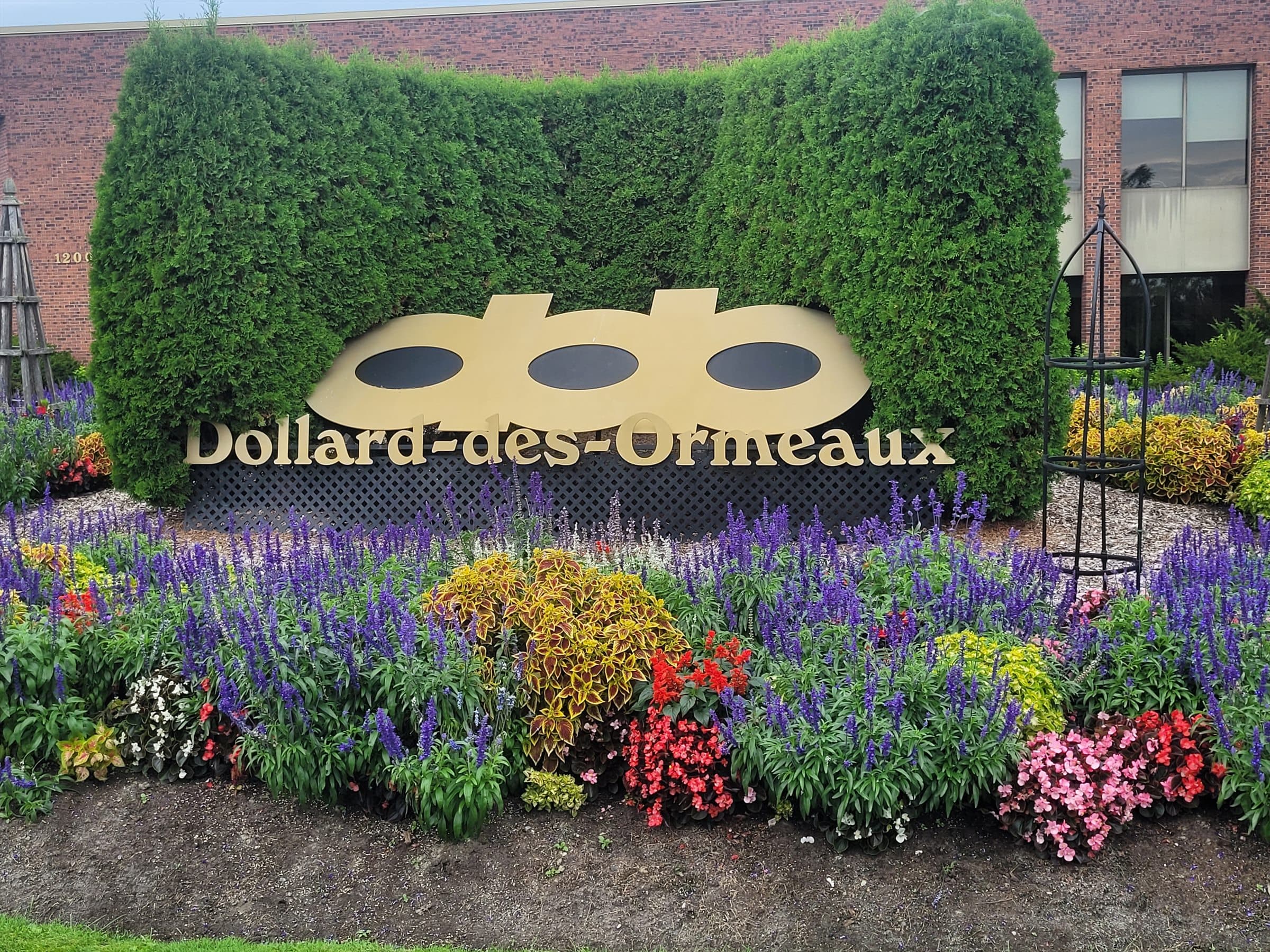 Dollard-des-Ormeaux sign surrounded by colourful flower gardens
